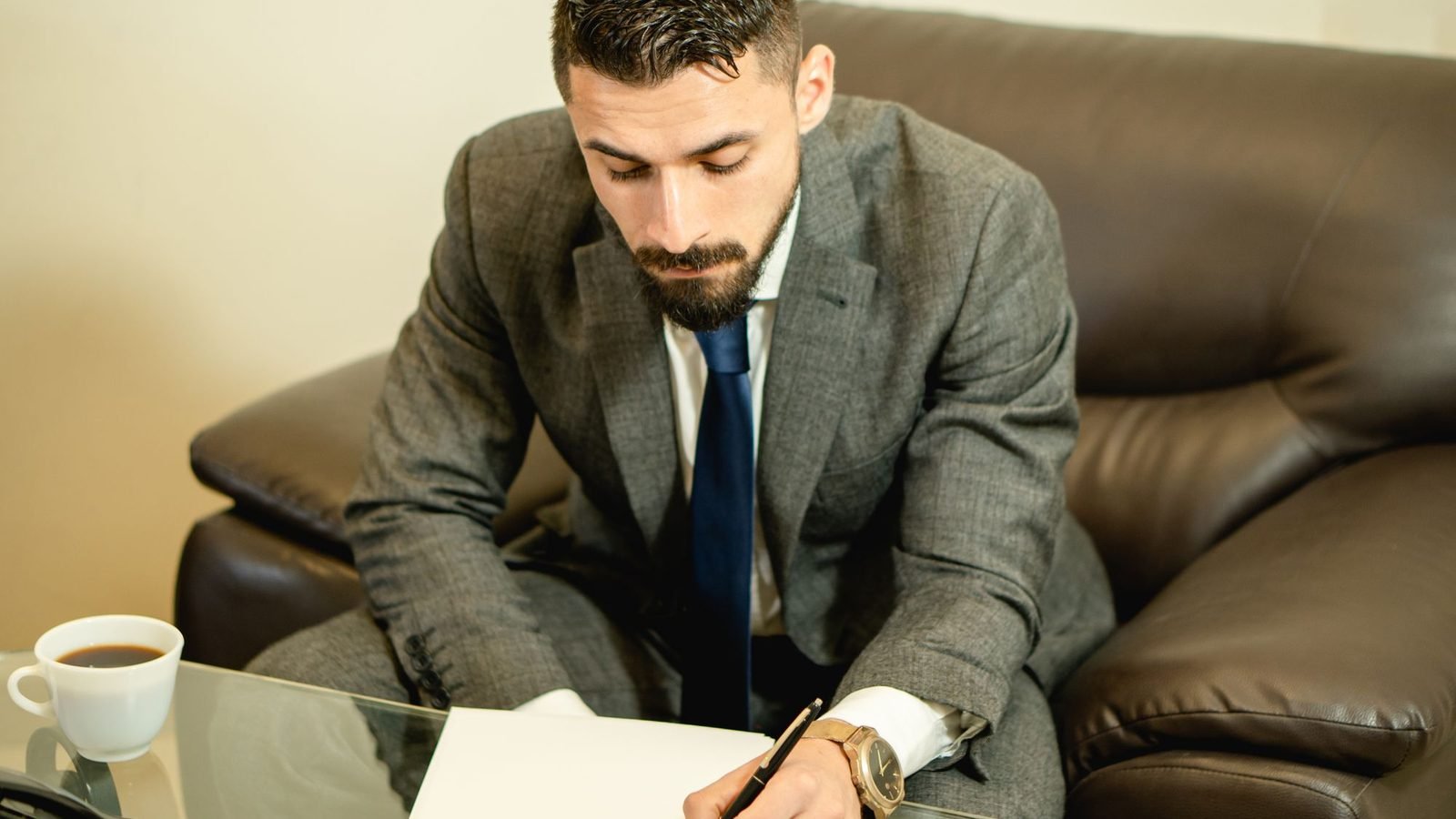 رجل بزي رسمي يوقّع أوراقاً على طاولة قبل توكيل للتعامل مع الجهات الحكومية